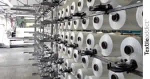 photo de bobines de fils dévidées sur l'ensouple pendant l'ourdissage pour le tissage