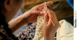 Artisan crochetant une couverture avec des fils écologiques en coton biologique
