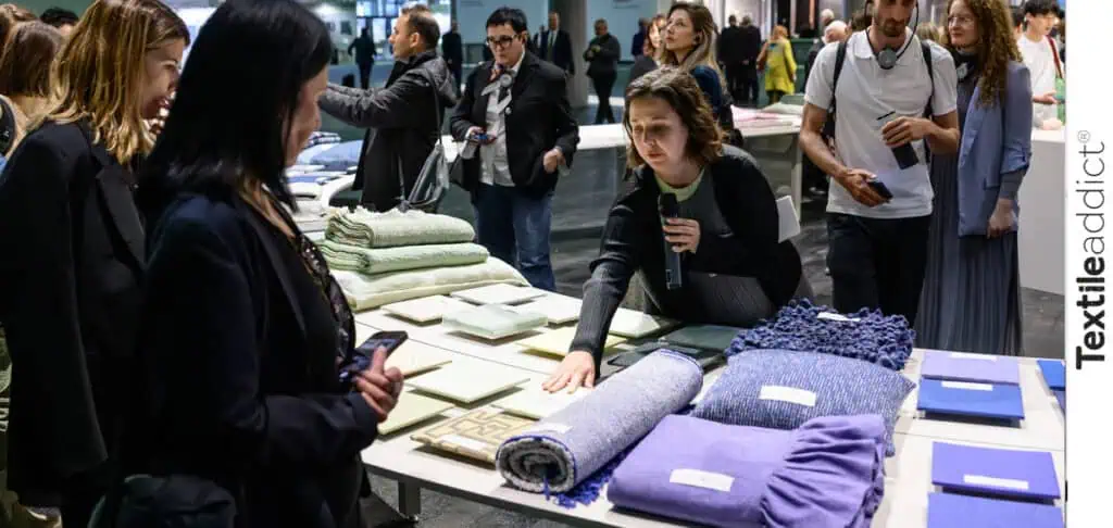 photo d'un espace tendances de Heimtextil Francfort, avec des textiles décoratifs colorés et des professionnels en discussion