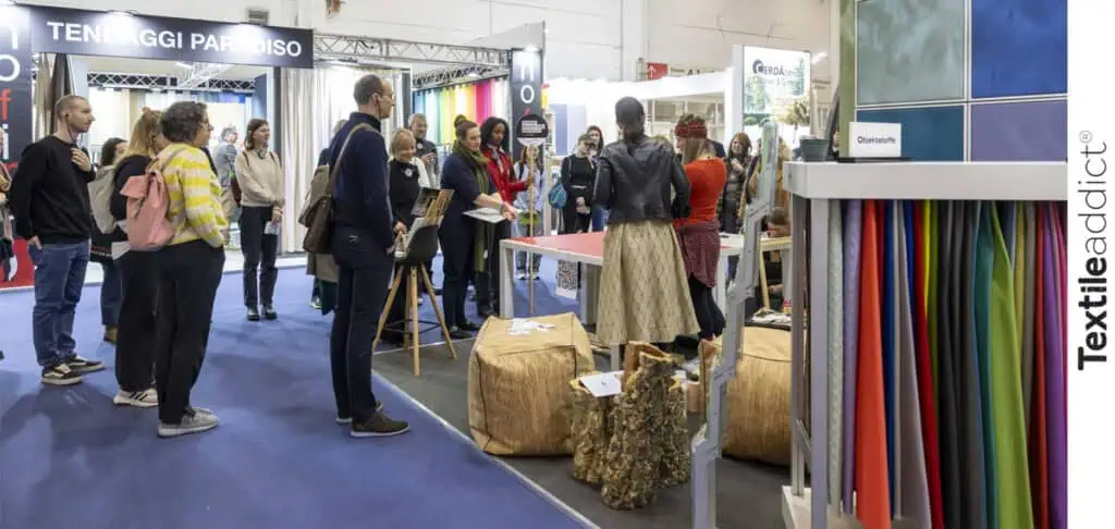 Un stand lors d’un salon textile, exposant des motifs et tissus innovants